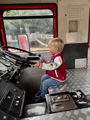 Toddler playing inside a real sized fire engine at Battersea Park Childrens Zoo